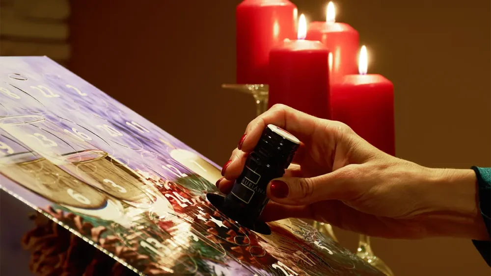 Ruka vytahuje lahev vína z adventního kalendáře vín od Dárková vína.cz