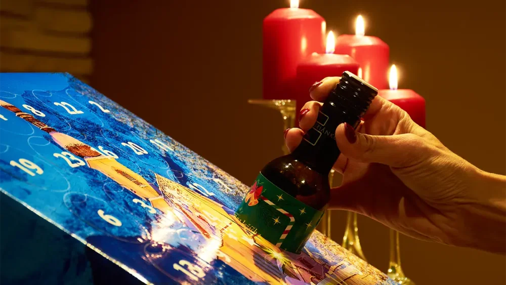 Ruka vytahuje lahev vína z adventního kalendáře vín od Dárková vína.cz